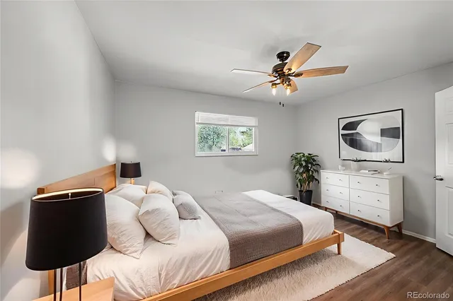 a bedroom with a bed and a lamp on table and a window