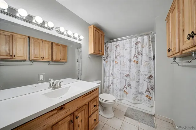 a bathroom with a sink a toilet a mirror and shower