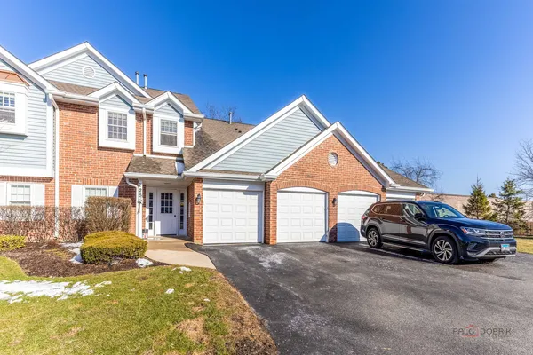 a front view of a house with cars parked