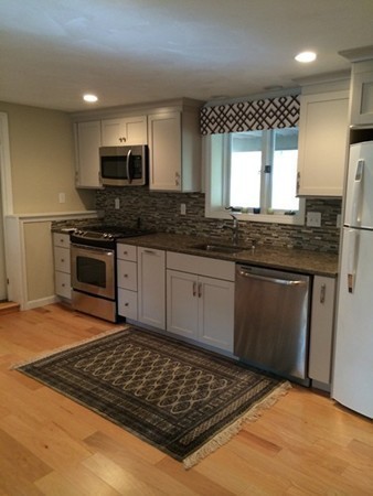 16 Wason Road Hudson, NH 03051 - Photo 8 of 18 a kitchen with stainless steel appliances granite countertop a stove a sink and a microwave