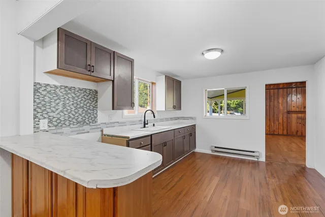 a kitchen with sink cabinets and wooden floor