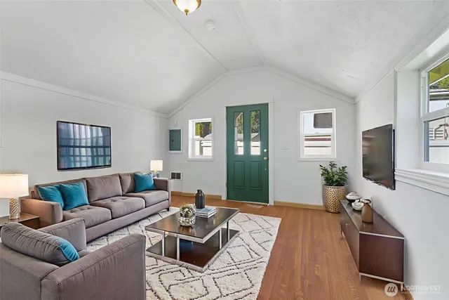 a living room with furniture a flat screen tv and a window