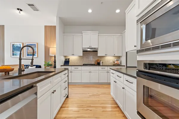 a kitchen with stainless steel appliances granite countertop a stove sink and cabinets