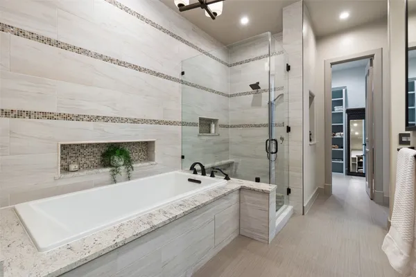a bathroom with a tub a double vanity sink a mirror a shower and vanity