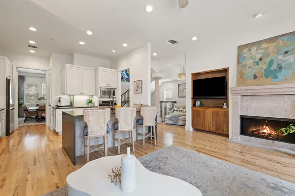 a living room with stainless steel appliances furniture fireplace and flat screen tv