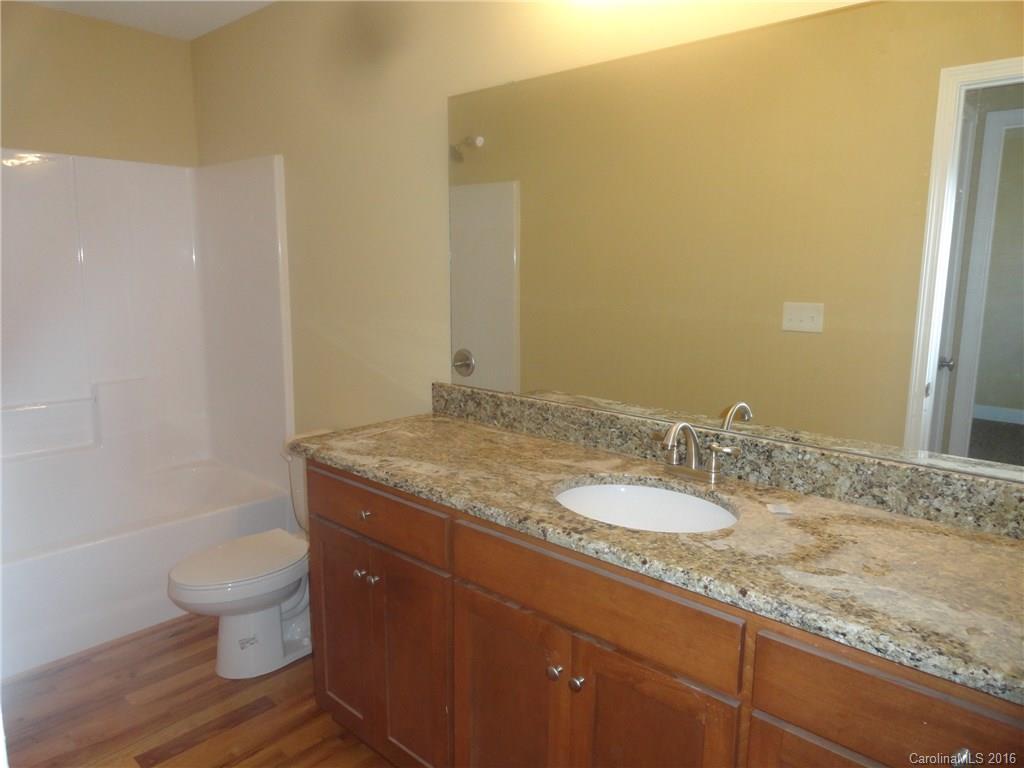 4759 Kemp Dellinger Road, Unit 1 Maiden, NC 28650 - Photo 14 of 24 a bathroom with a granite countertop sink a toilet and a mirror
