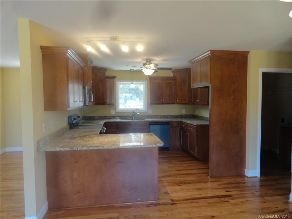 4759 Kemp Dellinger Road, Unit 1 Maiden, NC 28650 - Photo 8 of 24 a kitchen with kitchen island granite countertop a sink cabinets and stainless steel appliances