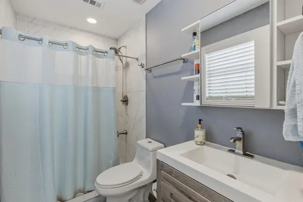 a bathroom with a sink a toilet and shower