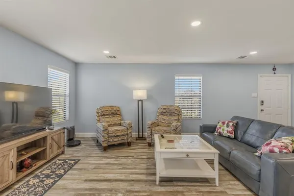 a living room with furniture and wooden floor