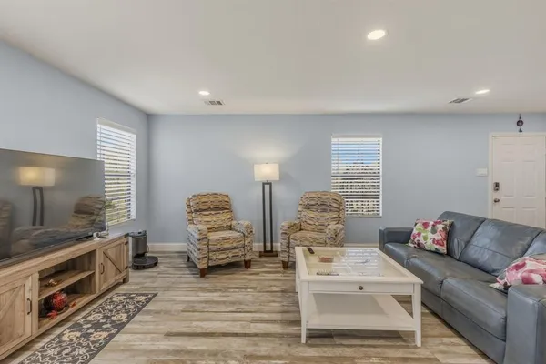 a living room with furniture a flat screen tv and a fireplace