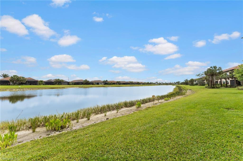 15244 Zeno Way, Unit 201 Naples, FL 34114 - Photo 12 of 50 a view of a lake and houses in the back