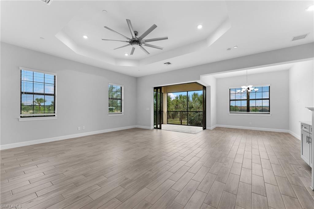 15244 Zeno Way, Unit 201 Naples, FL 34114 - Photo 18 of 50 a view of an empty room with wooden floor and a window