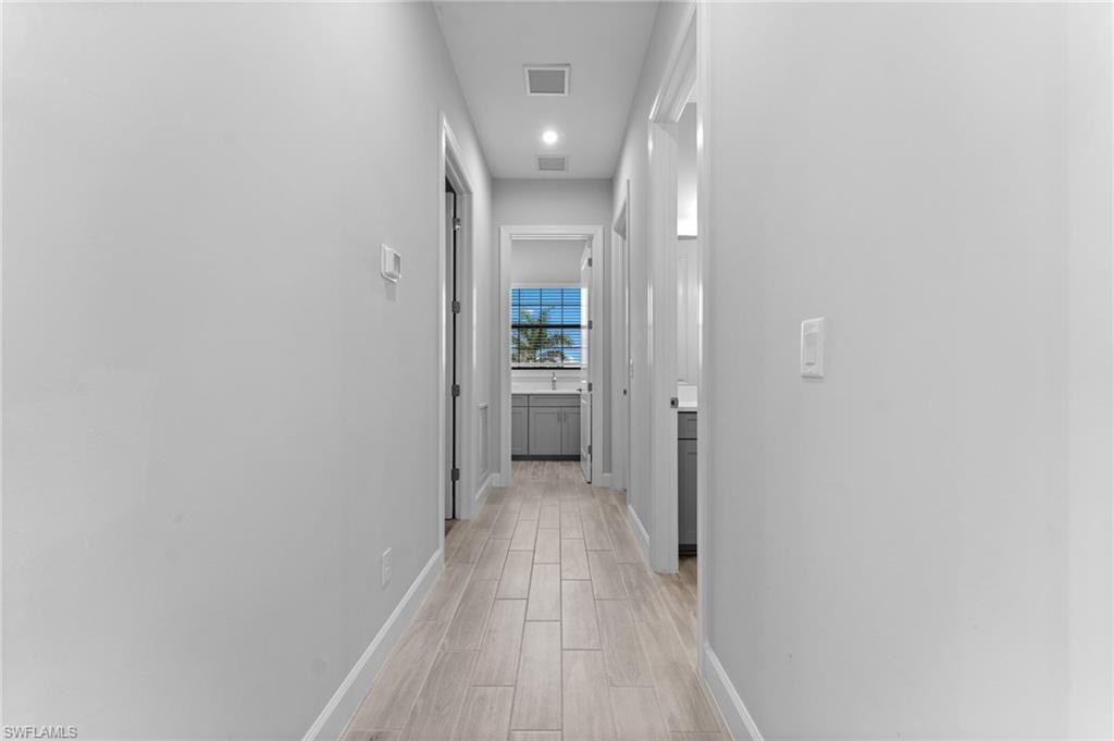 15244 Zeno Way, Unit 201 Naples, FL 34114 - Photo 31 of 50 a view of a hallway with wooden floor