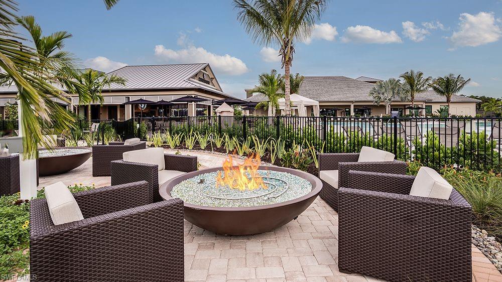 15244 Zeno Way, Unit 201 Naples, FL 34114 - Photo 50 of 50 a view of a patio with couches table and chairs potted plants and palm tree