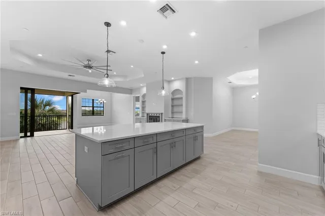 a large kitchen with kitchen island a large island in it