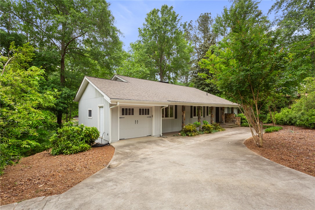 5 High Tide Court Salem, SC 29676 - Photo 34 of 40 This charming home features a convenient garage and a long, inviting driveway amidst lush greenery.