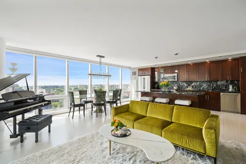 a living room with furniture and a view of kitchen