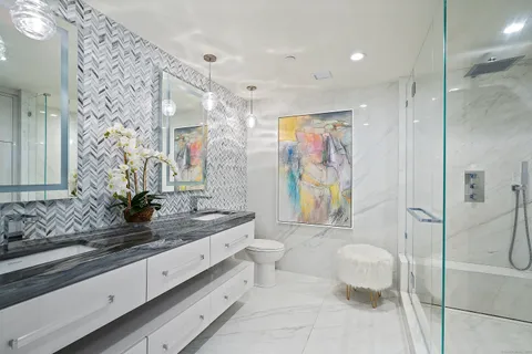 a spacious bathroom with a double vanity sink toilet and shower