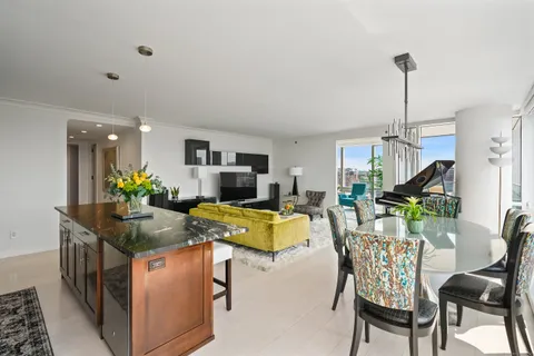 a kitchen with a table chairs and a living room