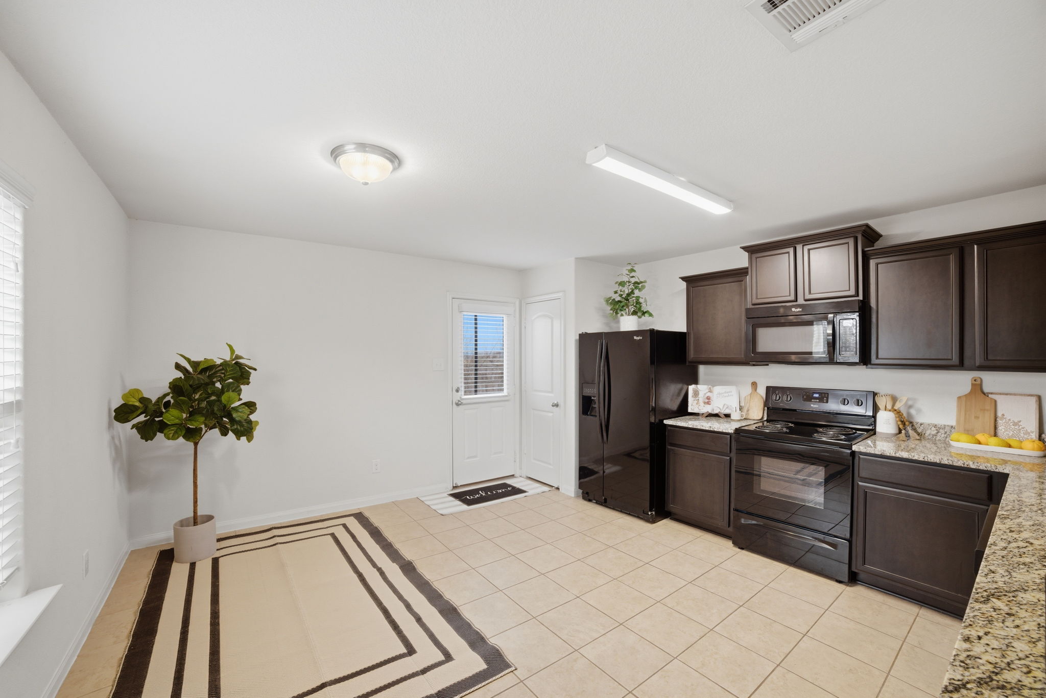 107 Millers Loop Jarrell, TX 76537 - Photo 7 of 31 a kitchen with stainless steel appliances kitchen island granite countertop a refrigerator and a sink