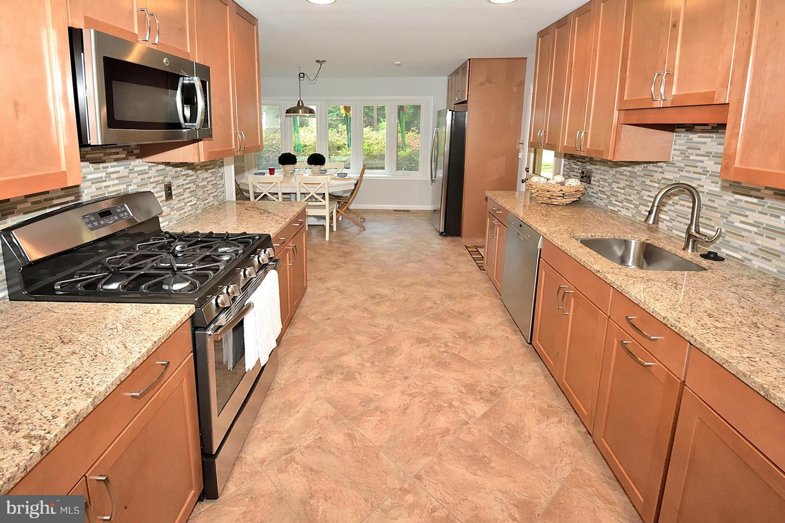 5613 Ravenel Lane Springfield, VA 22151 - Photo 11 of 30 a kitchen with granite countertop a sink stove and refrigerator