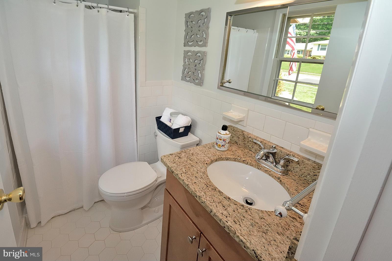 5613 Ravenel Lane Springfield, VA 22151 - Photo 16 of 30 a bathroom with a granite countertop sink toilet and mirror