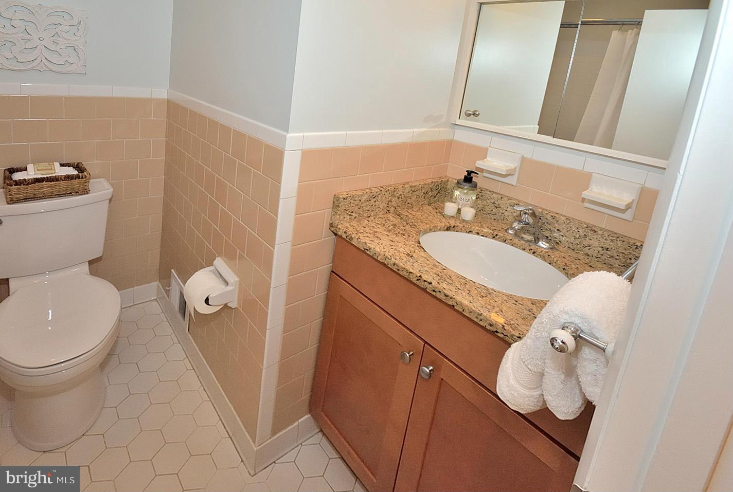 5613 Ravenel Lane Springfield, VA 22151 - Photo 19 of 30 a bathroom with a granite countertop sink toilet and mirror