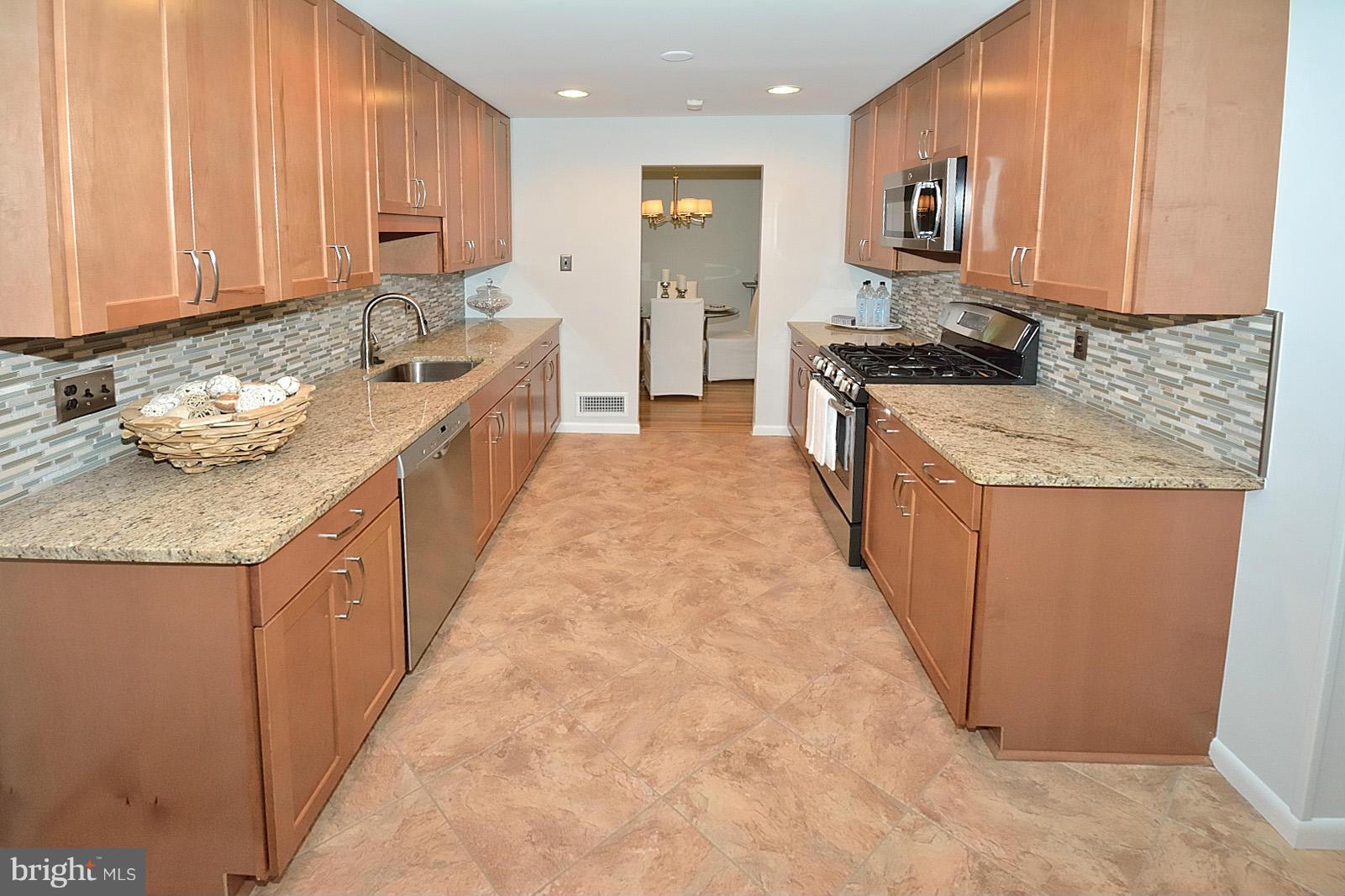 5613 Ravenel Lane Springfield, VA 22151 - Photo 9 of 30 a kitchen with stainless steel appliances granite countertop a stove a sink and a refrigerator
