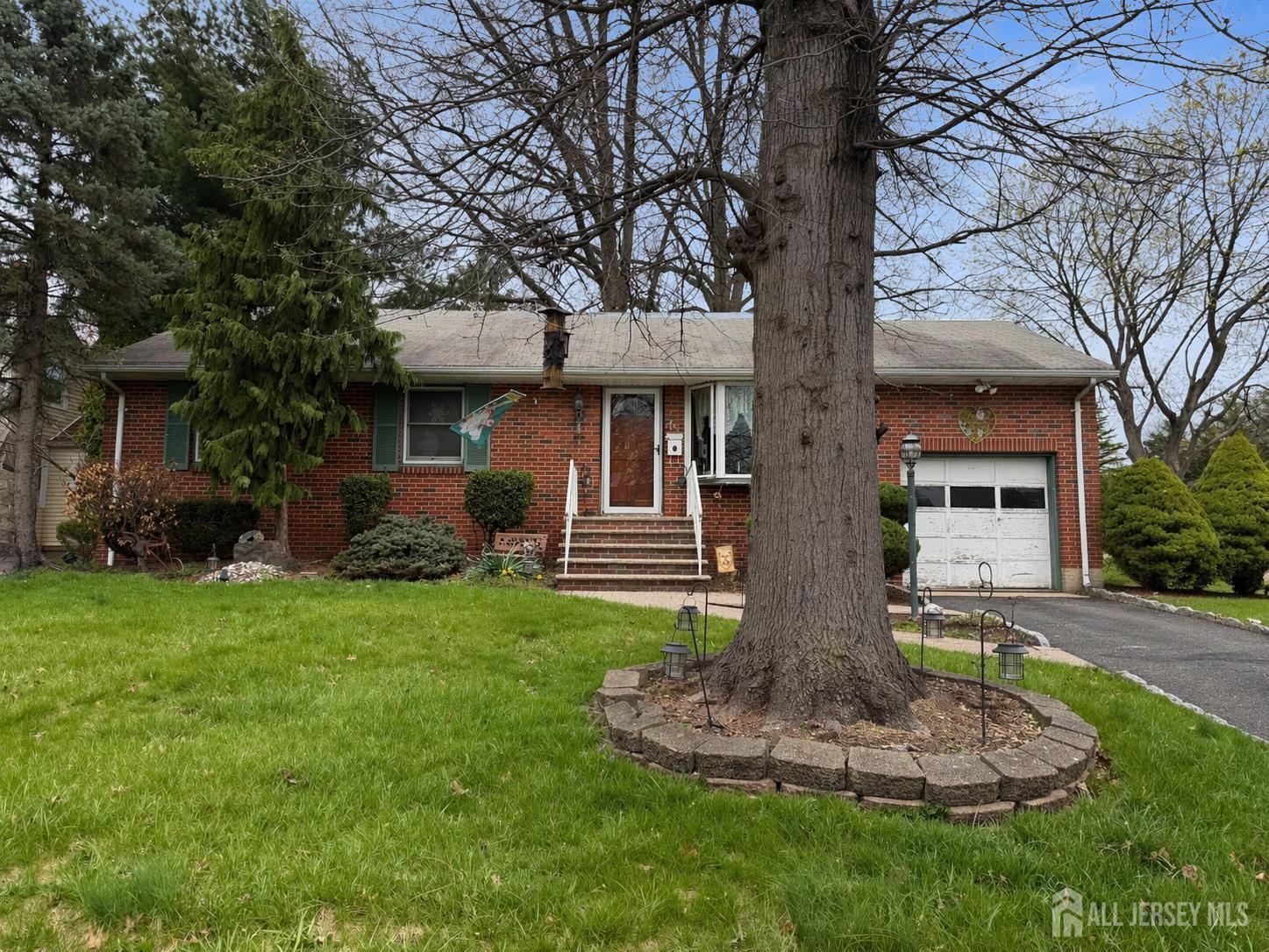 48 Morningside Road Colonia, NJ 07067 - Photo 4 of 4 a front view of a house with a garden and trees