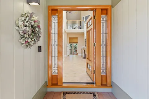 a living room with furniture large window and chandelier