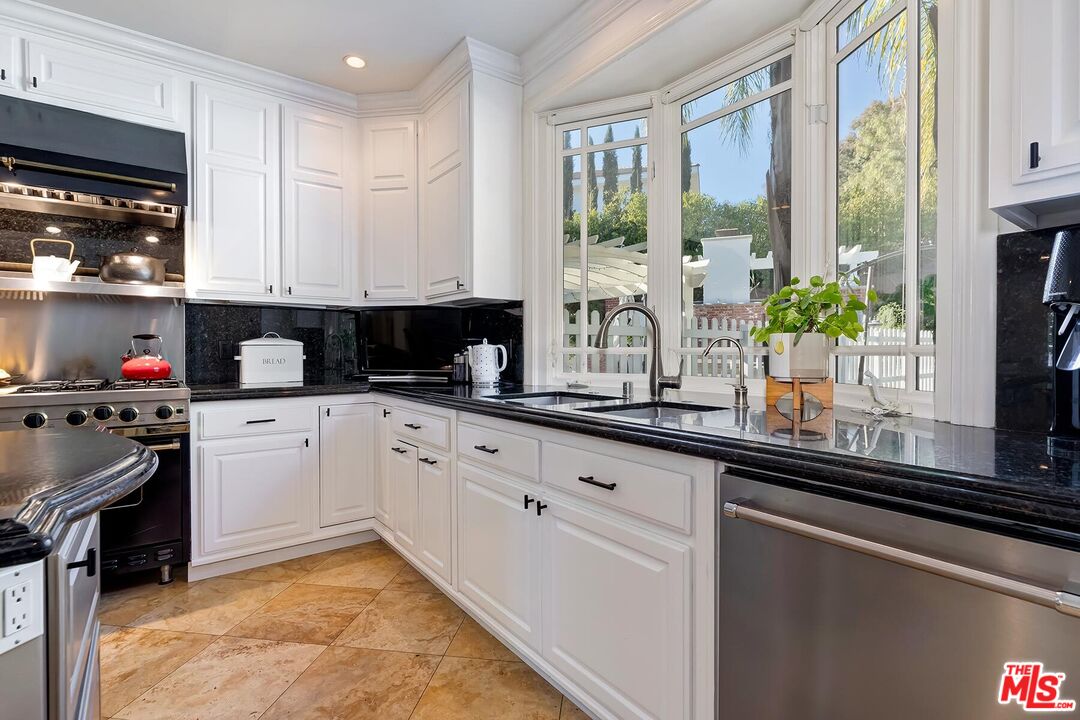 3827 Castle View Road Agoura Hills, CA 91301 - Photo 32 of 74 a kitchen with granite countertop white cabinets and white appliances