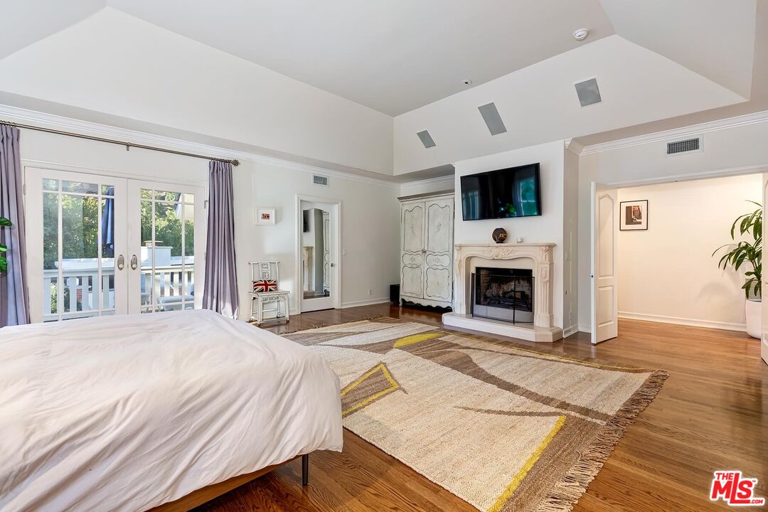 3827 Castle View Road Agoura Hills, CA 91301 - Photo 40 of 74 a spacious bedroom with a bed a fireplace and a large window