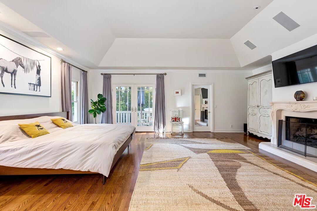 3827 Castle View Road Agoura Hills, CA 91301 - Photo 41 of 74 a bedroom with a bed a flat screen tv and large window