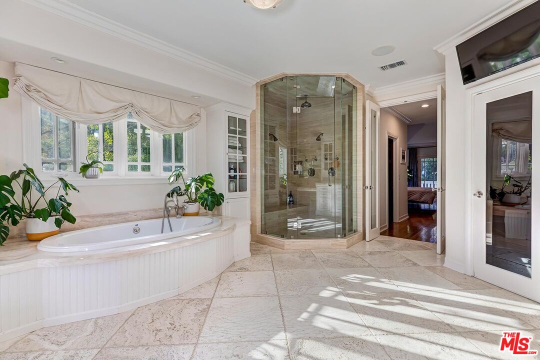 3827 Castle View Road Agoura Hills, CA 91301 - Photo 46 of 74 a spacious bathroom with a bathtub shower and mirror