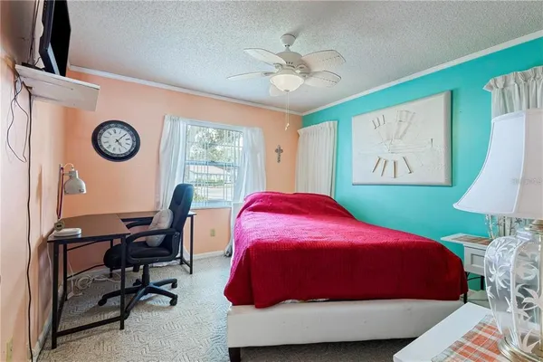 a bedroom with a bed and a lamp on dresser