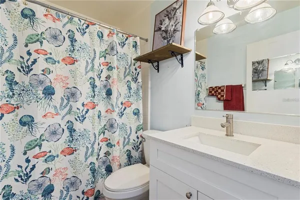a bathroom with a sink and mirror with toilet