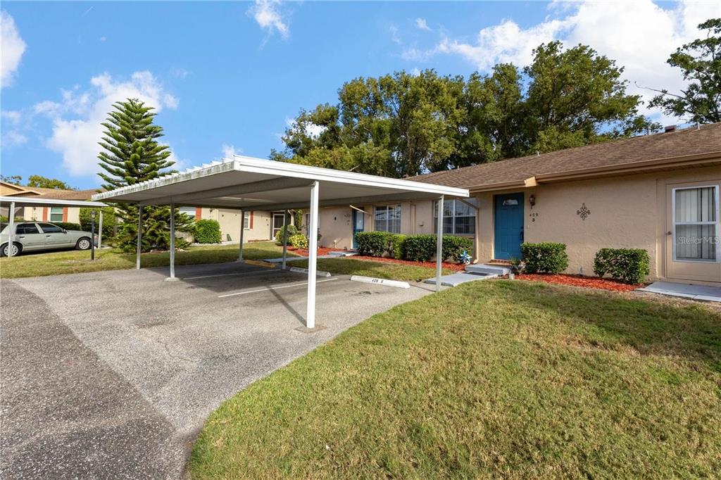 409 Feltham Trail, Unit B Sun City Center, FL 33573 - Photo 2 of 34 a view of a patio with table and chairs under an umbrella