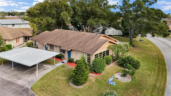 an aerial view of a house with yard and swimming pool