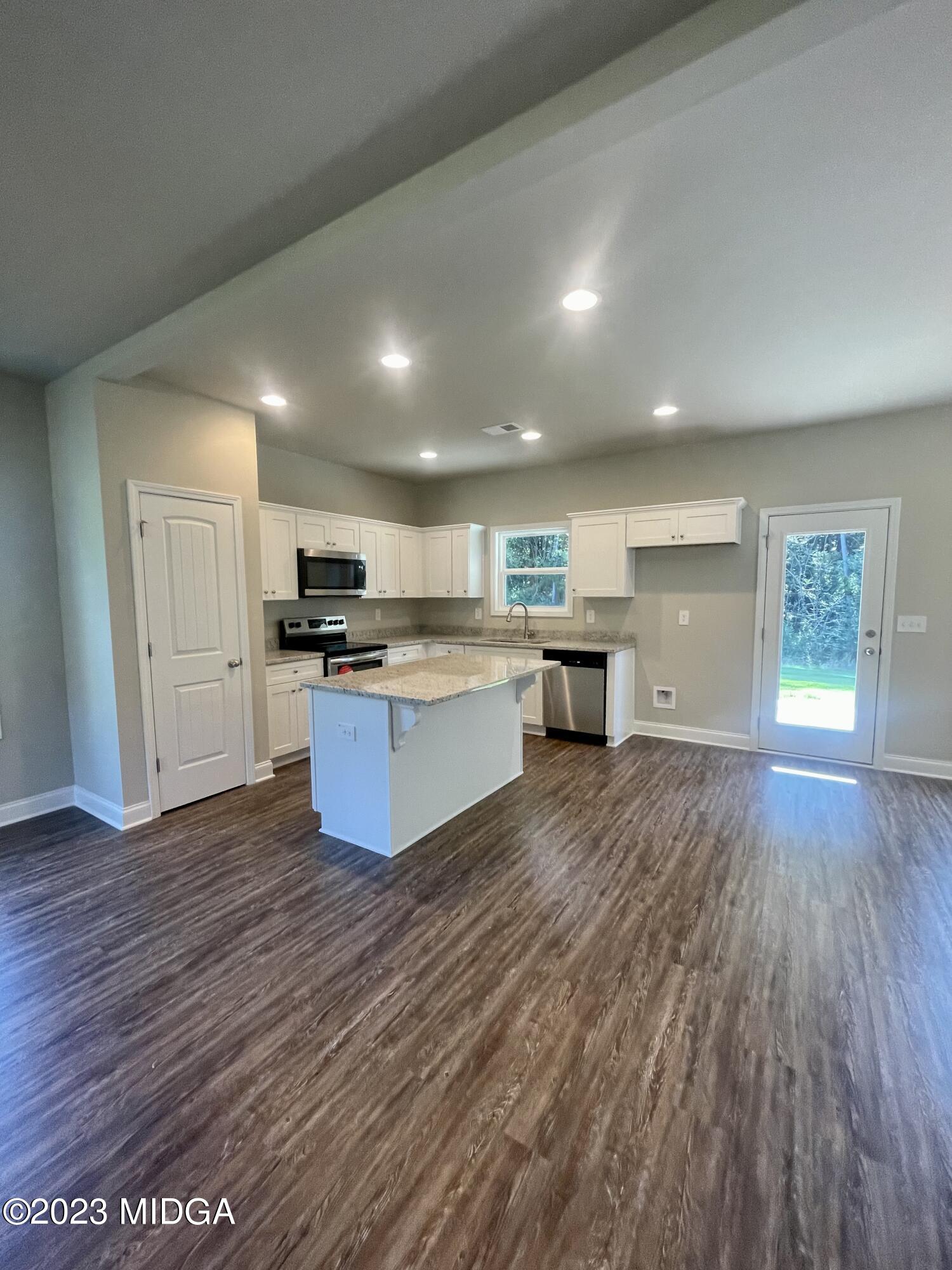 23 Strickland Loop Forsyth, GA 31029 - Photo 3 of 9 a large kitchen with stainless steel appliances granite countertop a stove a sink and a refrigerator