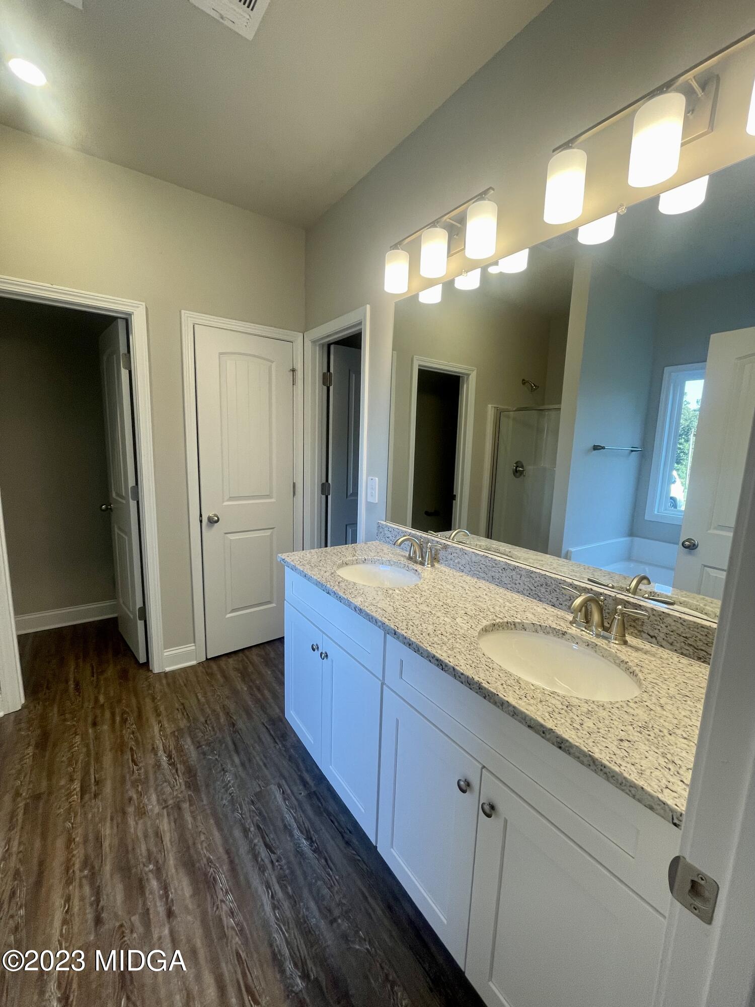 23 Strickland Loop Forsyth, GA 31029 - Photo 6 of 9 a bathroom with a granite countertop sink and a mirror
