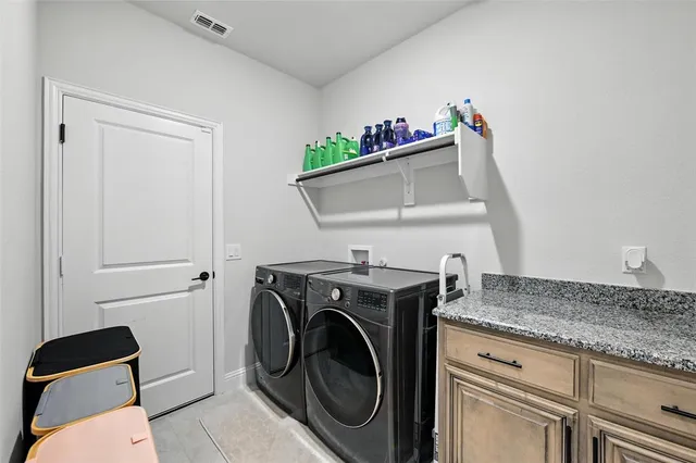 a utility room with sink dryer and washer