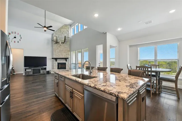 a large kitchen with kitchen island a stove a sink a dining table and chairs