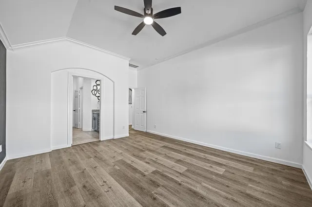 a view of empty room with wooden floor