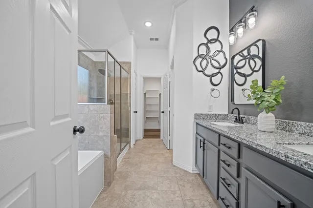 a spacious bathroom with a granite countertop sink a mirror a shower and a bathtub