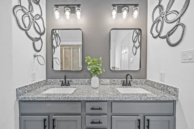 a bathroom with double vanity sinks and a mirror