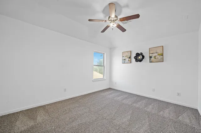 a view of room with ceiling fan and window