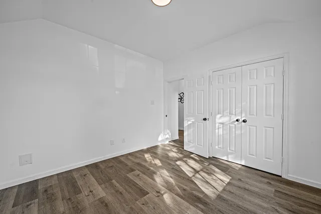 a view of a room with wooden floor