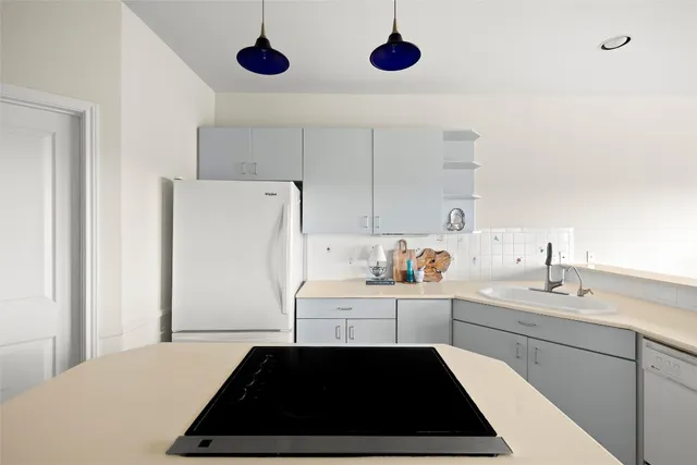 a kitchen with a refrigerator a sink dishwasher a stove and a refrigerator with wooden floor