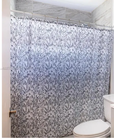 a white toilet sitting next to a shower curtain