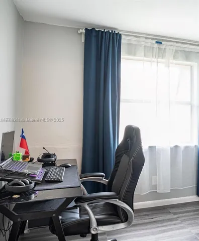 a view of a workspace with furniture and a window